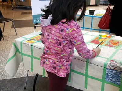 Young person painting on the Community Canvas